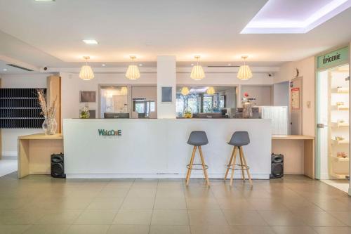 a store with two stools in front of a counter at Zenitude Hôtel Résidences - Marseille Prado Plage in Marseille