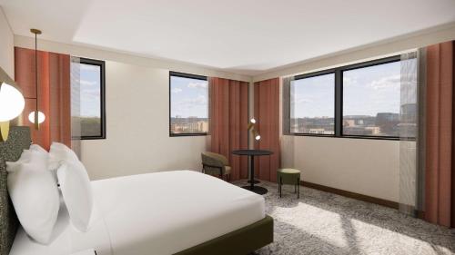 ein Hotelzimmer mit einem weißen Bett und Fenstern in der Unterkunft Doubletree By Hilton Sheffield City in Sheffield