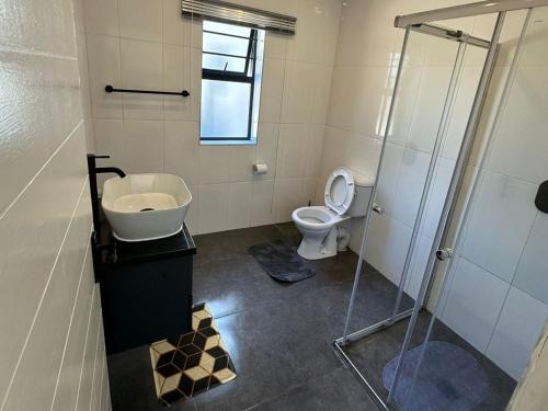 y baño con aseo, lavabo y ducha. en Conti-INN Guesthouse, en Queenstown