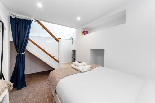 sypialnia z łóżkiem i schodami w obiekcie Comfy 3BR grd floor flat wprivate garden, NE w Londynie