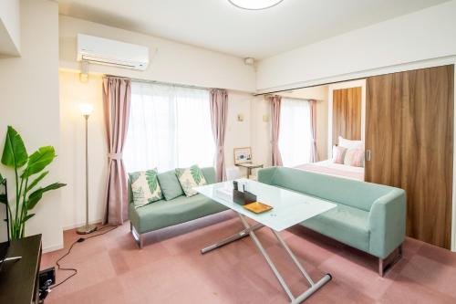 宜野灣的住宿－はなハウス 3F，客厅配有沙发、桌子和床。