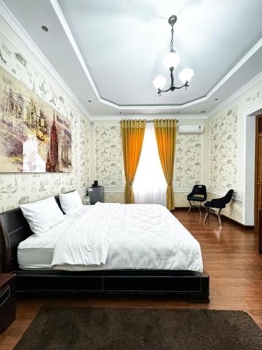 a bedroom with a large white bed and a desk at De Villa Hotel in Samarkand