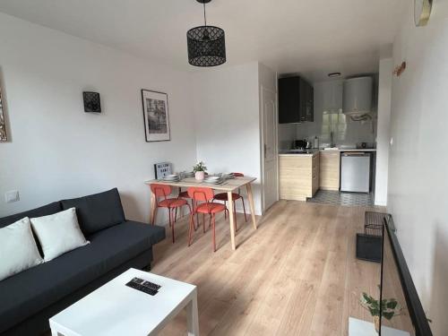 un salon avec un canapé et une table et une cuisine dans l'établissement WD Saint Roch - Appartement 101 - Métro 7 Proche Paris, à Villejuif