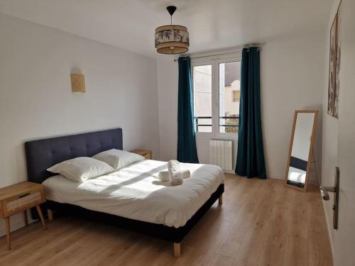 une chambre avec un lit, un miroir et une fenêtre dans l'établissement WD Saint Roch - Appartement 101 - Métro 7 Proche Paris, à Villejuif