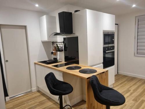 une cuisine avec deux tabourets de bar et un comptoir dans l'établissement apparemment cosy & chic, à Rezé