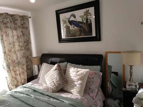 a bedroom with a bed with pillows and a picture on the wall at House Rose 1 in Prescot
