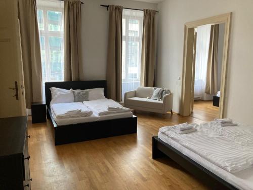 a bedroom with two beds and a chair in it at Top Wenceslas Square Apartment in Prague