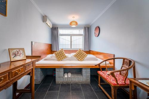 Habitación con cama, escritorio y silla. en Xi'an See Tang Guesthouse en Xi'an