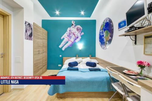 1 dormitorio con cama y pared azul en Little Americas Opera Apts, en Budapest