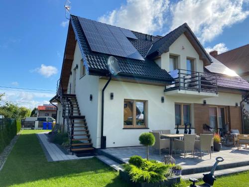 ein Haus mit Sonnenkollektoren auf dem Dach in der Unterkunft Miło Cię widzieć in Łeba