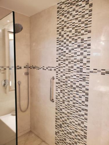 a bathroom with a shower with a glass door at Amaryl The Dream St Lawrence Gap 2BR condo with pool in Christ Church