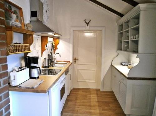 a small kitchen with white cabinets and a sink at Welcome Home + Terrasse in Winterberg