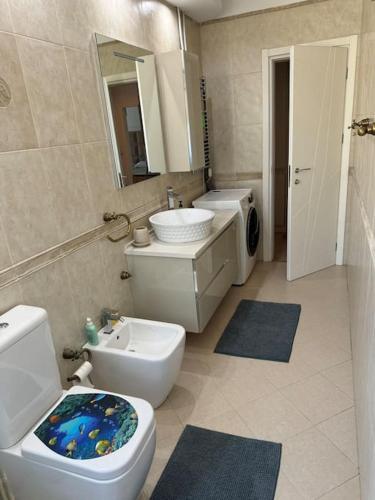 een badkamer met een wit toilet en een wastafel bij Leos Apartment in Tirana
