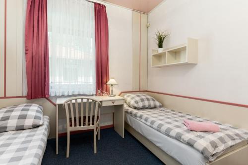 a room with two beds and a desk and a window at Relaks Domki pod Górą Żar in Międzybrodzie Żywieckie