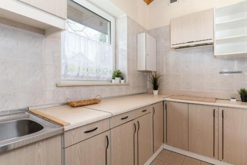 a kitchen with wooden cabinets and a sink and a window at Relaks Domki pod Górą Żar in Międzybrodzie Żywieckie