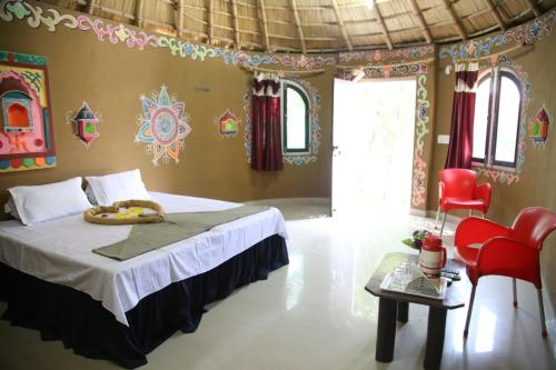 een slaapkamer met een bed en een tafel en stoelen bij Padmini Heritage Resort in Ajmer