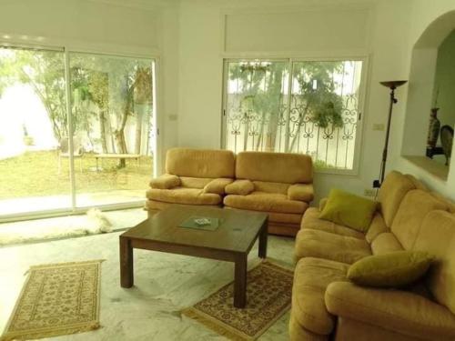 a living room with a couch and a coffee table at Villa à yasmine hammamet in Nabeul