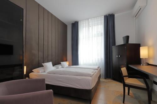 a hotel room with a bed and a desk and a computer at DEVIN Art Hotel in Düsseldorf