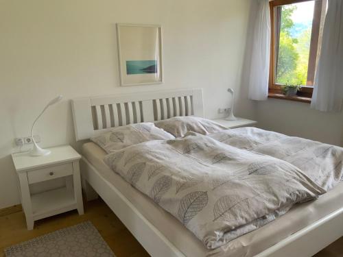 a bed with a white comforter in a bedroom at Ferienwohnung Christensen in Murnau am Staffelsee