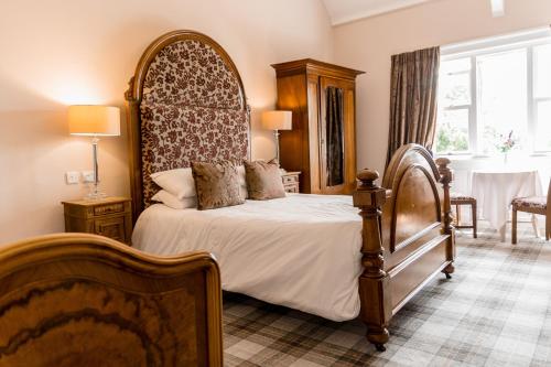 a bedroom with a bed with a large headboard at Sweeney Hall Hotel in Oswestry