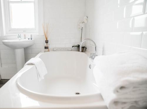 a white bathroom with a tub and a sink at Sweeney Hall Hotel in Oswestry