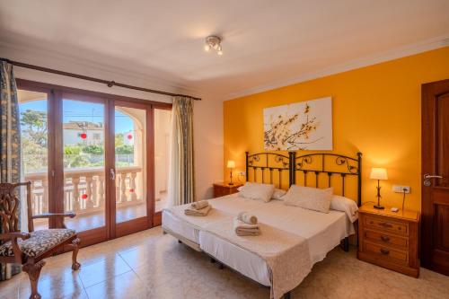 a bedroom with a bed and a large window at Villa Pons in Playa de Muro