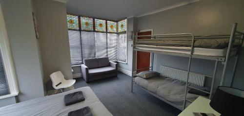 Cette petite chambre comprend des lits superposés et une chaise. dans l'établissement Blackpool North Close to Station with Free Parking, à Blackpool