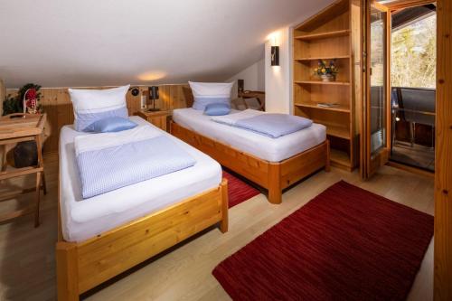twee bedden in een kamer met een rood tapijt bij Haus Ferienglück in Schönau am Königssee
