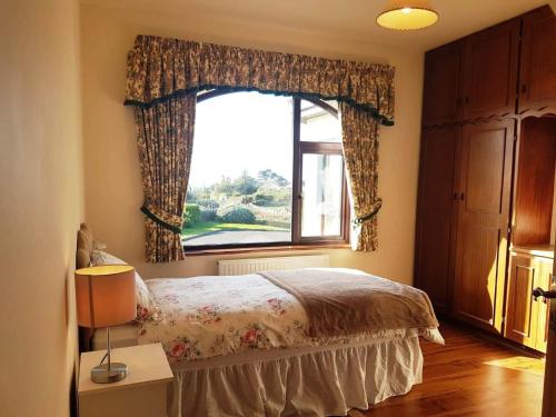een slaapkamer met een bed en een raam bij Pooreen House in Inverin