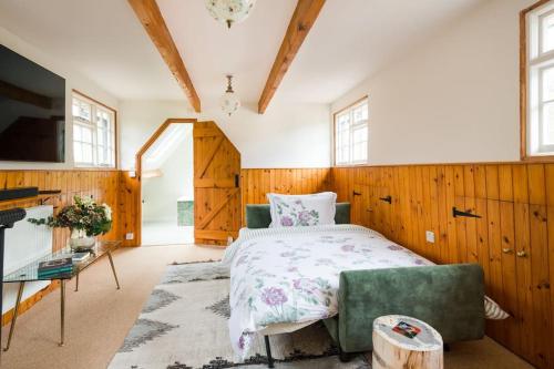 a bedroom with a bed and a couch and a tv at NEW Little Till - Riverside Cottage nr Stonehenge in Winterbourne Stoke