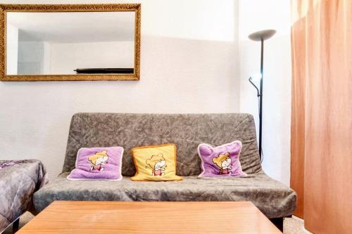 ein Wohnzimmer mit lila und gelben Kissen auf einer Couch in der Unterkunft Studio with wifi at Torremolinos 1 km away from the beach in Torremolinos