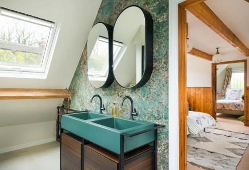 a bathroom with a green sink and a mirror at NEW Little Till - Riverside Cottage nr Stonehenge in Winterbourne Stoke