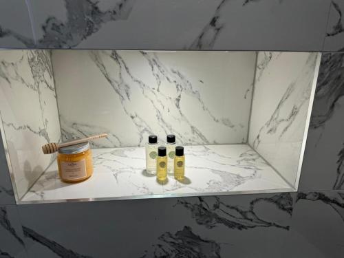 Un estante con tres botellas de aceites esenciales. en Casa Fresa - 224 King St, en Broughty Ferry