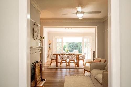a living room with a dining room table and a ceiling fan at Piper Belle in Tamworth