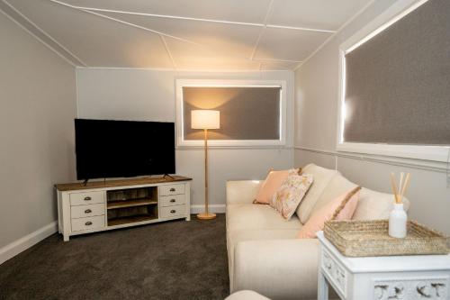 a living room with a couch and a flat screen tv at Piper Belle in Tamworth