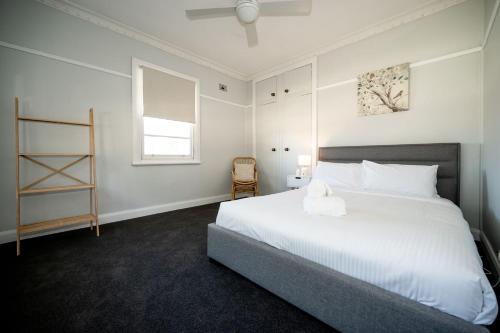 a bedroom with a large white bed and a window at Piper Belle in Tamworth