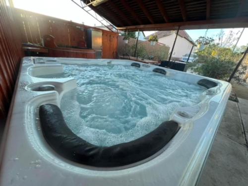 a jacuzzi tub with a black hose in it at Dor-Ka Vendégház Makó in Makó
