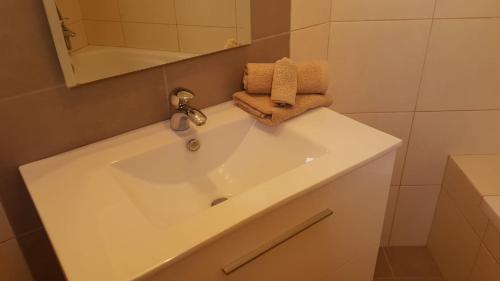ein weißes Waschbecken im Bad mit Spiegel in der Unterkunft Remarkable 3-Bed House in Machico in Machico