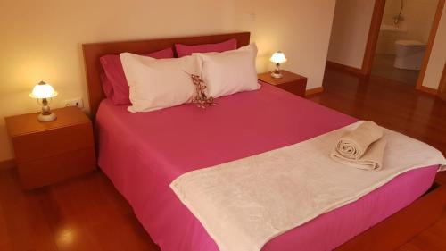 ein Schlafzimmer mit einem rosa Bett mit zwei Lampen in der Unterkunft Remarkable 3-Bed House in Machico in Machico