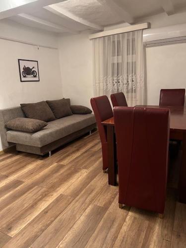 a living room with a couch and a table and chairs at Dor-Ka Vendégház Makó in Makó