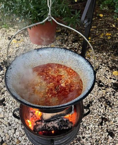 a pot of food is cooking on a grill at Dor-Ka Vendégház Makó in Makó