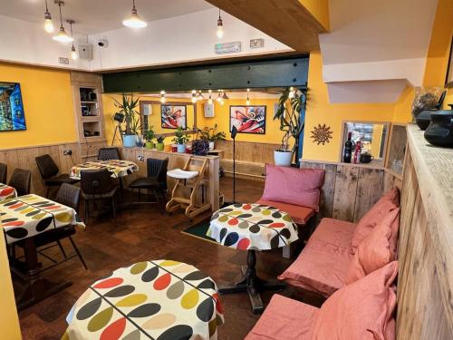 Zimmer mit Sofa, Tisch und Stühlen in der Unterkunft Hoopers Sandy Beach Guest Rooms in Swansea