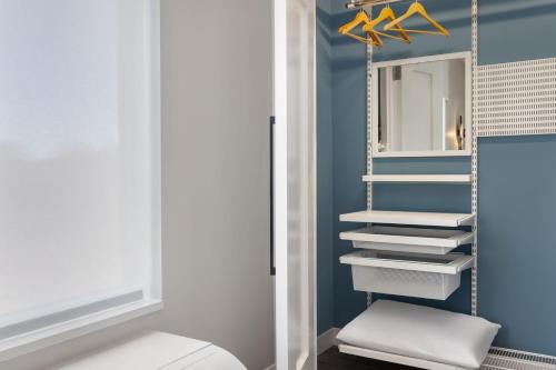 a bathroom with a white toilet and a mirror at TownePlace Suites by Marriott Geneva at SPIRE Academy in Geneva