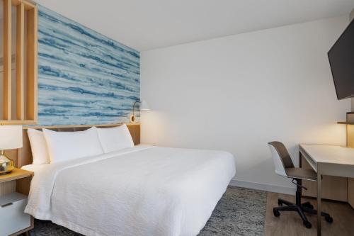 a hotel room with a bed and a desk at TownePlace Suites by Marriott Geneva at SPIRE Academy in Geneva