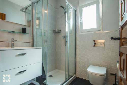 uma casa de banho com um chuveiro, um WC e um lavatório. em Villa Moonlight by Abahana Villas em Benitachell
