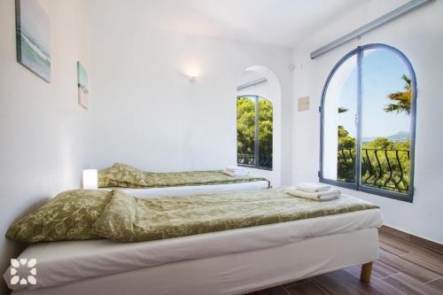 um quarto com 2 camas e uma grande janela em Villa Moonlight by Abahana Villas em Benitachell