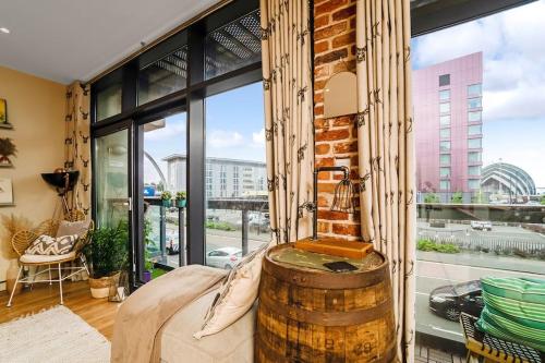 a room with a brick wall and a large window at Luxury Huge Modern Open Plan 2Bedroom Flat - Free Private Parking & Balcony located at the OVO Hydro and SEC Centre in Glasgow