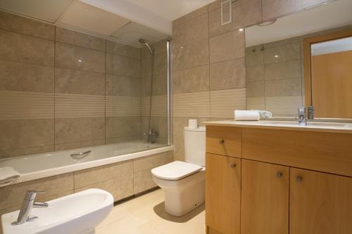a bathroom with a sink and a toilet and a tub at Ibersol Spa Aqquaria in Salou