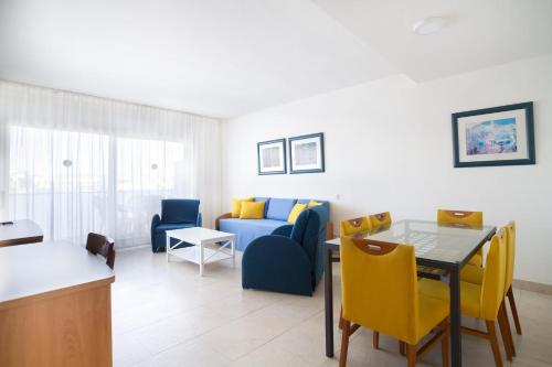 a living room with a couch and a table and chairs at Ibersol Spa Aqquaria in Salou