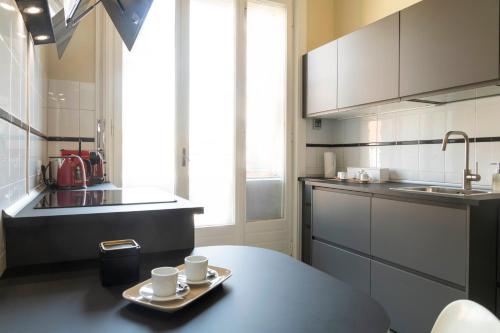 a kitchen with a table and two cups on a tray at Heart Milan Apartments San Sepolcro Duomo in Milan